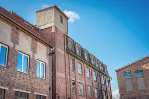 Historisches Backsteingebäude der Druckerei mit Turm vor blauem Himmel